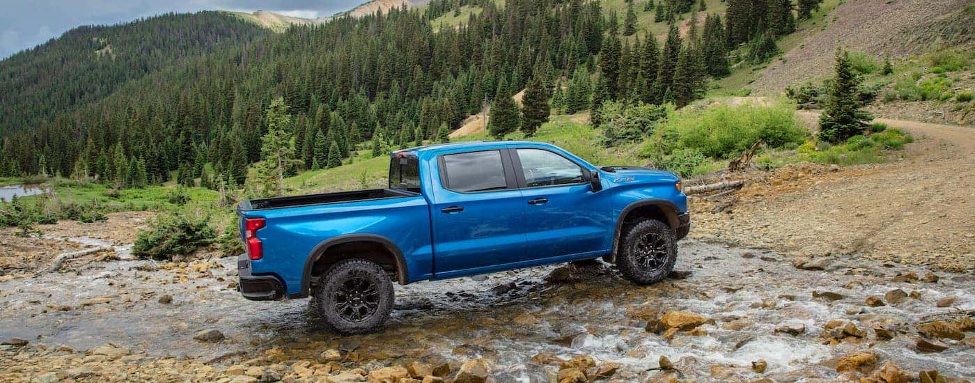 A blue 2024 Chevy Silverado 1500 ZR2 is shown from the side while off-road.