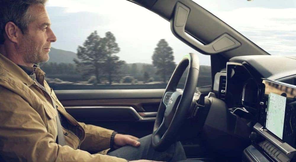 A person is shown utilizing Super Cruise in a 2024 Chevy Silverado 1500.