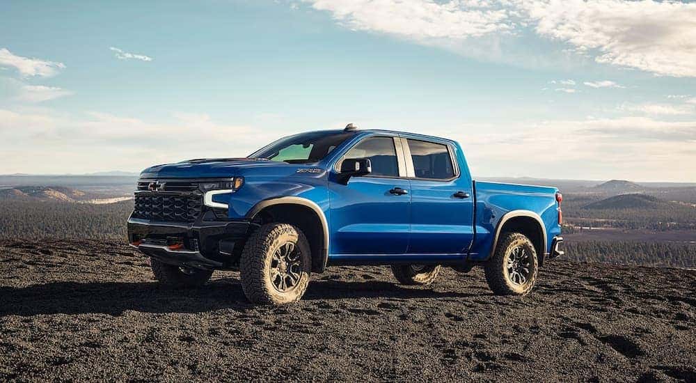 A blue 2024 Chevy Silverado 1500 ZR2 parked off-road on dirt.