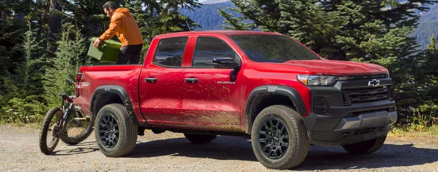 A red 2024 Chevy Colorado Trail Boss is shown parked on a dirt path.