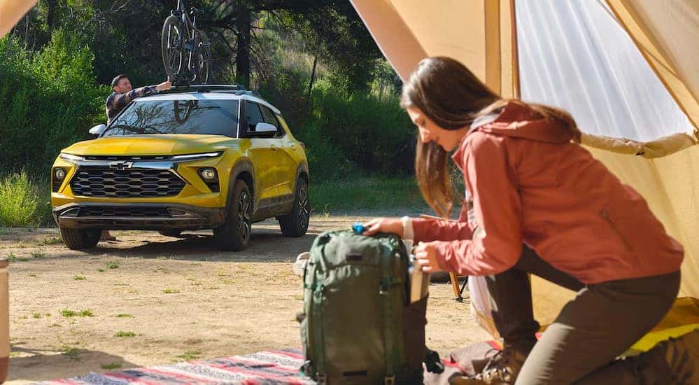 A yellow 2024 Chevy Trailblazer ACTIV is shown parked near a tent.