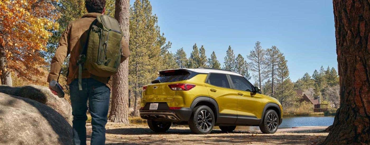 A hiker is shown approaching a yellow 2023 Chevy Trailblazer ACTIV.