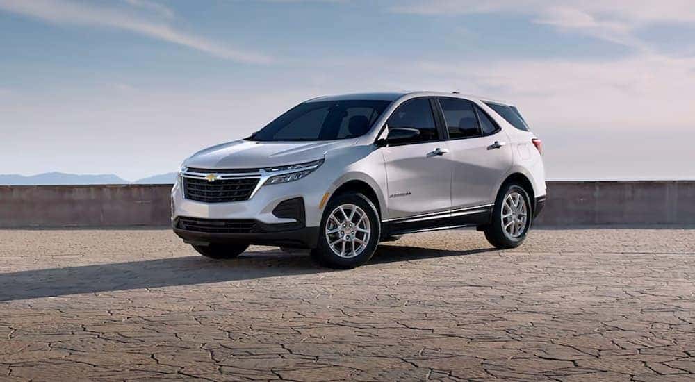 A silver 2024 Chevy Equinox LS parked under a blue sky.
