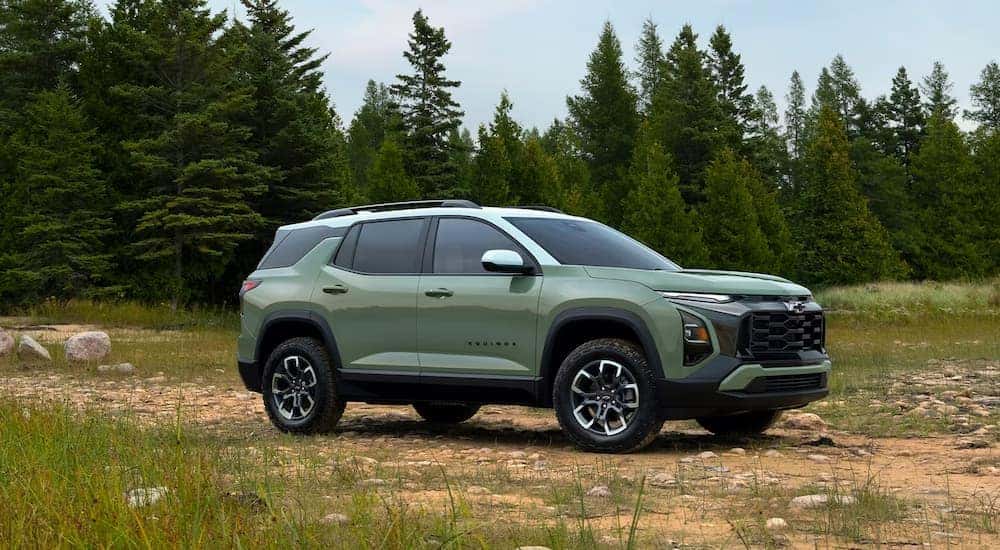 A light green 2025 Chevy Equinox ACTIV parked in a meadow.