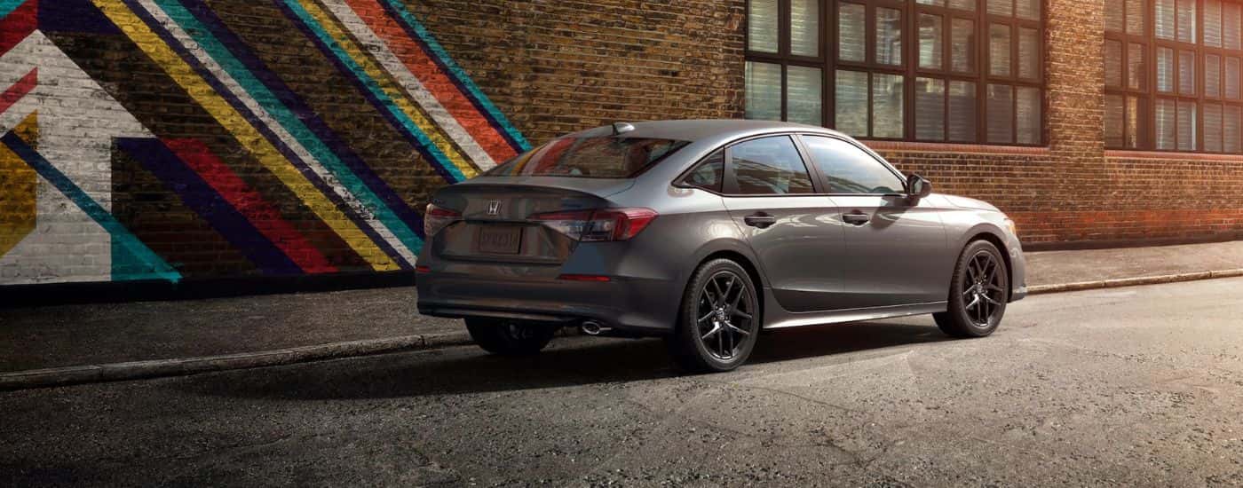 Grey 2026 Honda Civic parked next to a painted brick building.