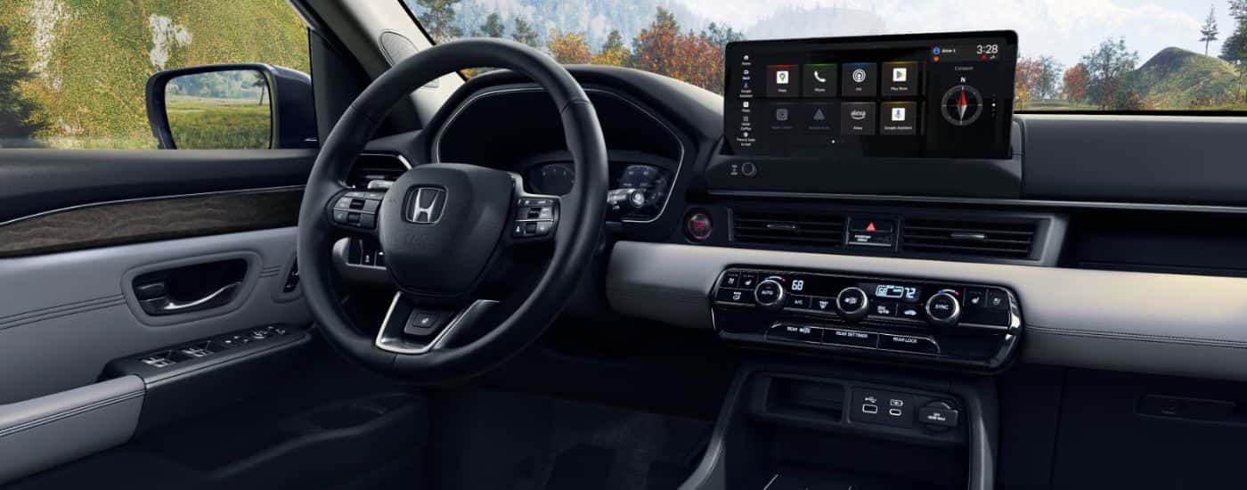 Interior view of a 2026 Honda Pilot infotainment display and steering wheel.