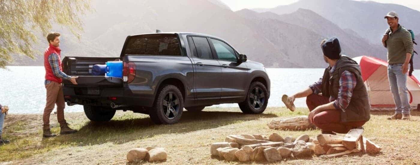 A silver 2026 Honda Ridgeline parked near a lake.