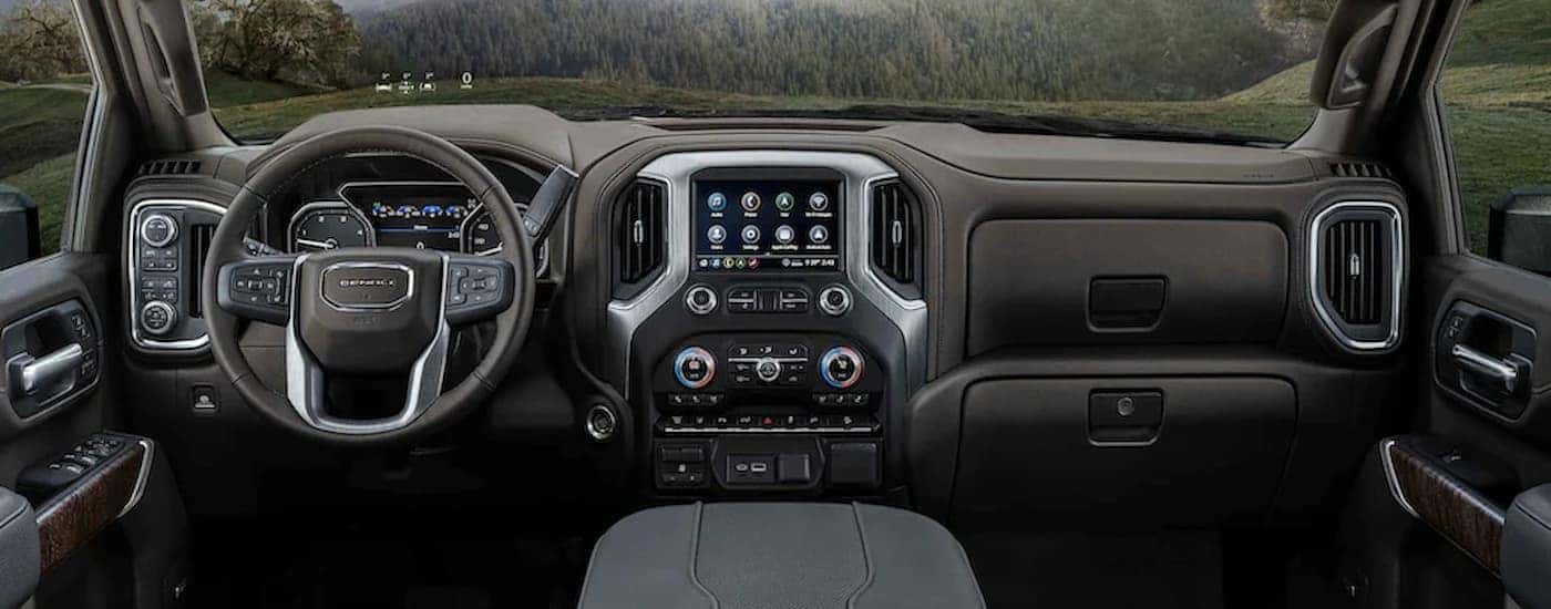 The dashboard of a 2023 GMC Sierra 2500 HD shows the steering wheel and infotainment screen.