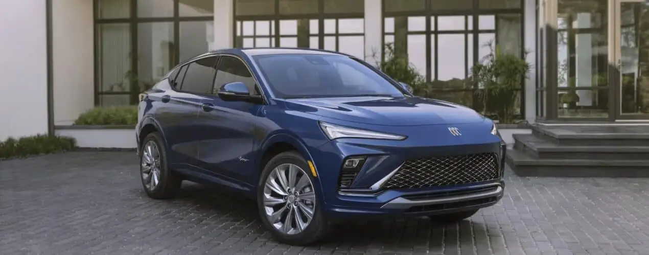 A blue 2024 Buick Envista Avenir is shown parked in a driveway.