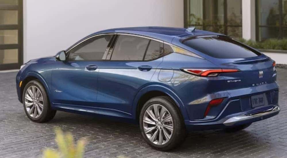A blue 2024 Buick Envista is shown parked near a house.