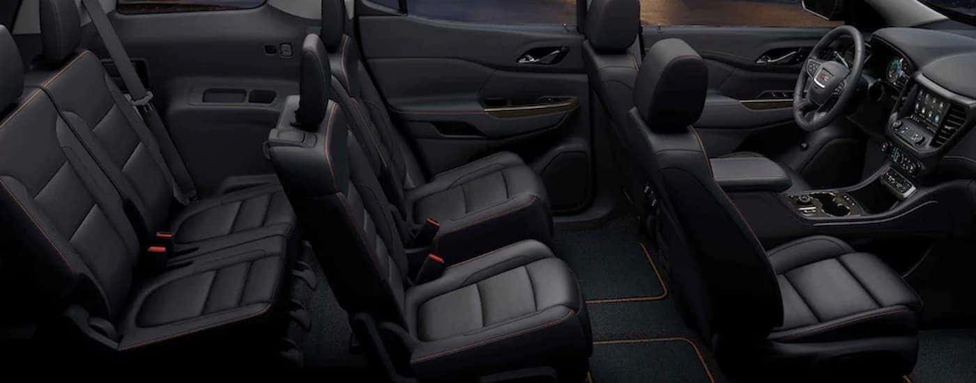 The black interior fo a 2023 GMC Acadia AT4 shows three rows of seating.