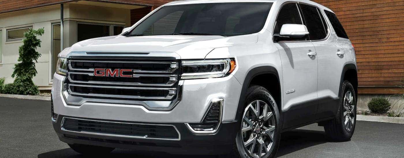 A white 2023 GMC Acadia SLE is shown parked on a driveway.