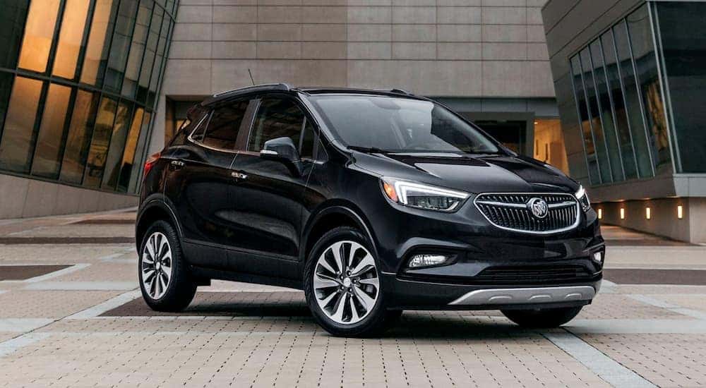 A black 2020 Buick Encore is shown parked outside of a building.