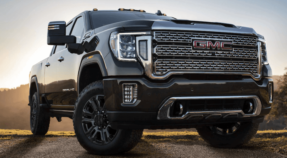 A black 2024 GMC Sierra 3500 HD is shown parked off-road.