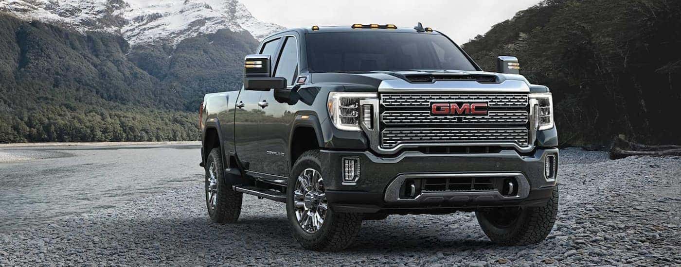 A black 2024 GMC Sierra 3500 HD is shown parked off-road.