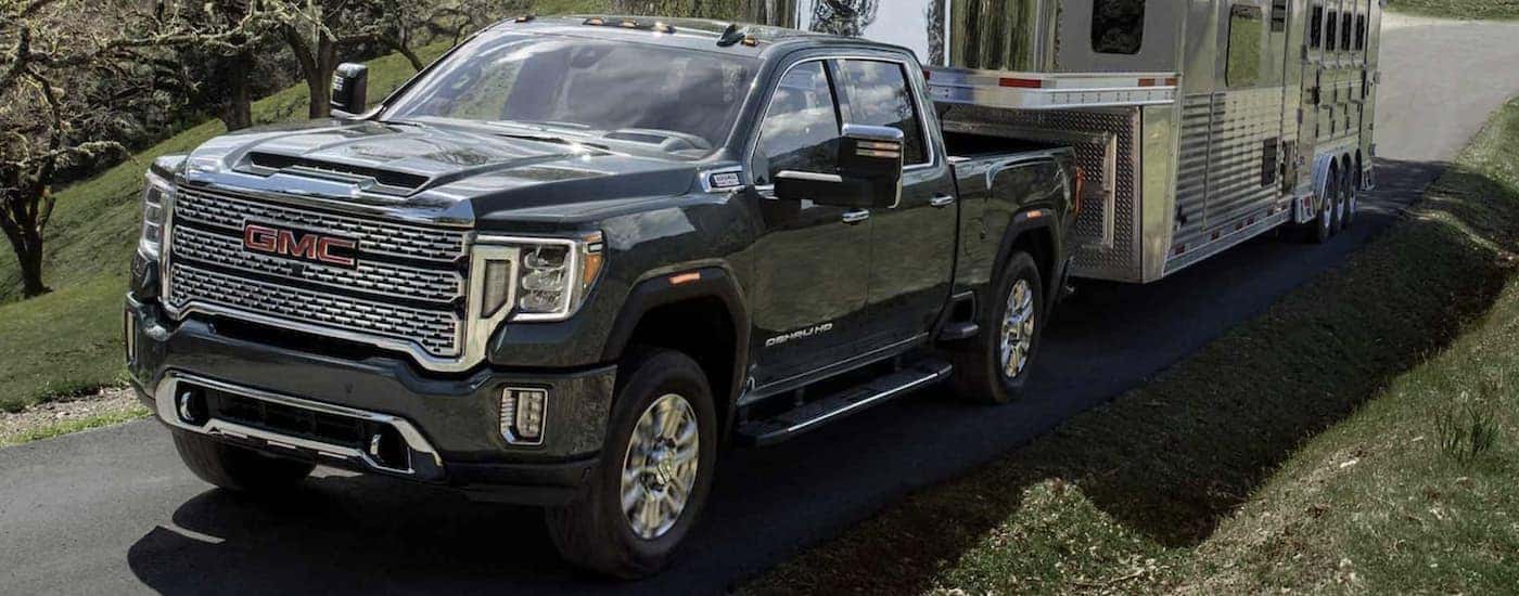 A black 2024 GMC Sierra 3500 HD is shown towing a trailer.