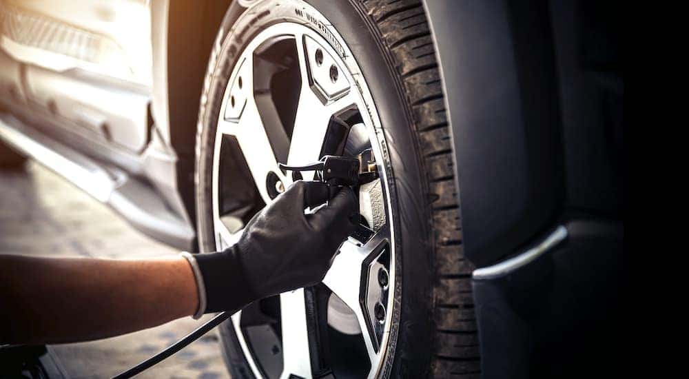 A mechanic is shown refilling a tire at a Buick service center.