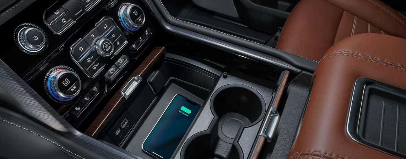 The black and brown interior and center console area is shown in a 2024 GMC Yukon.