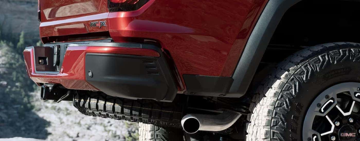 Close-up of the tailgate and back tire of a red 2024 GMC Canyon AT4.