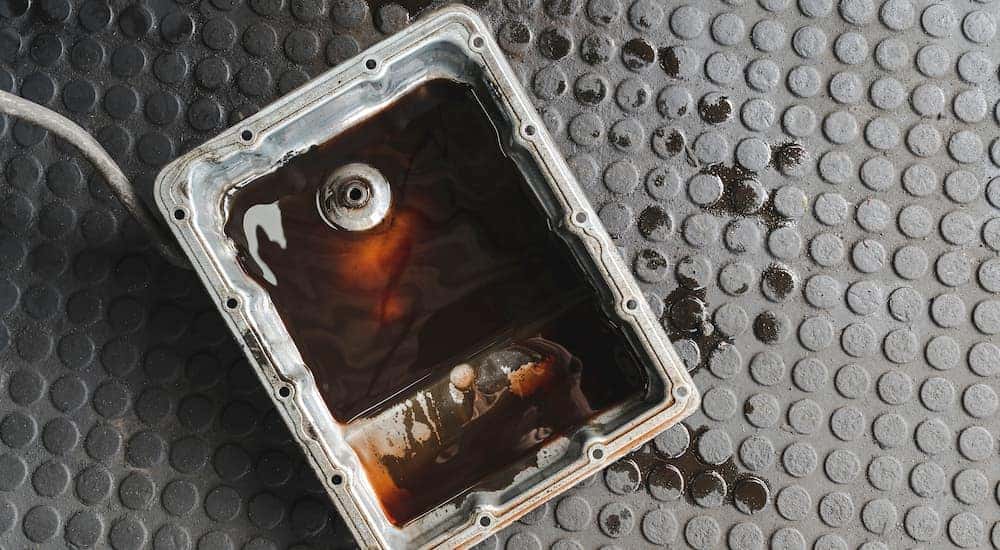 A pan of transmission fluid is shown on the ground.