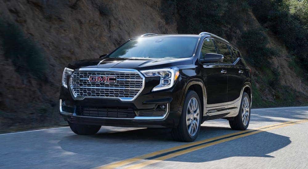 A black 2024 GMC Terrain Denali is shown from the front at an angle.