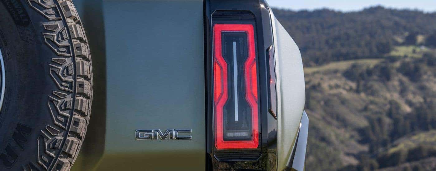 A close up shows the passenger side taillight on a green 2024 GMC Hummer EV SUV.