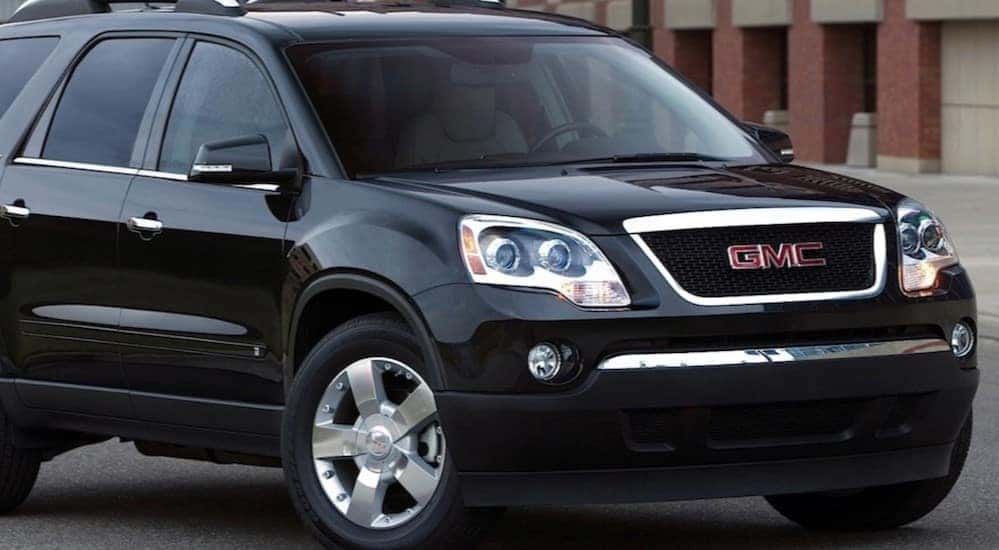A black 2007 GMC Acadia is shown parked near a building.