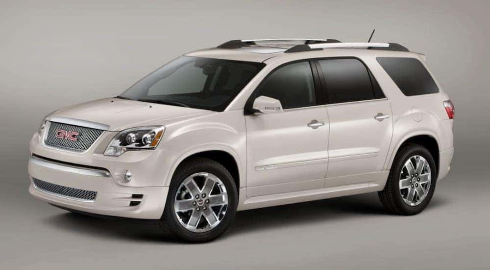 A white 2007 GMC Acadia Denali is shown parked near a GMC dealer near Johns Creek.