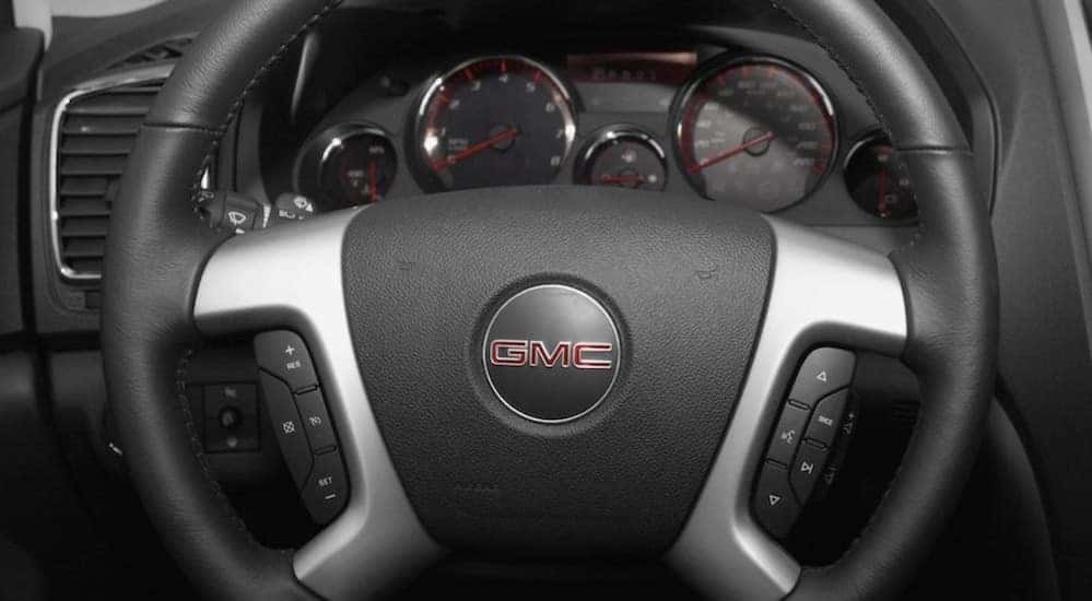 A close-up of a steering wheel is shown in a 2007 GMC Acadia.