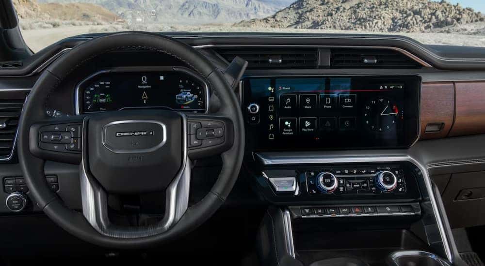 The steering wheel and infotainment screen in a 2025 GMC Sierra 2500 HD Denali.