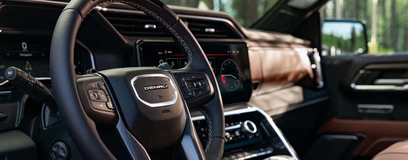 A close-up of the steering wheel and dash are shown in a 2025 GMC Sierra 1500 Denali.