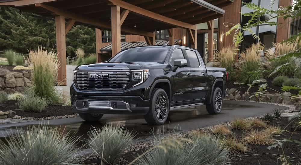 A black 2024 GMC Sierra Denali Ultimate is shown from the front after leaving a dealer that sells GMC Denali models.