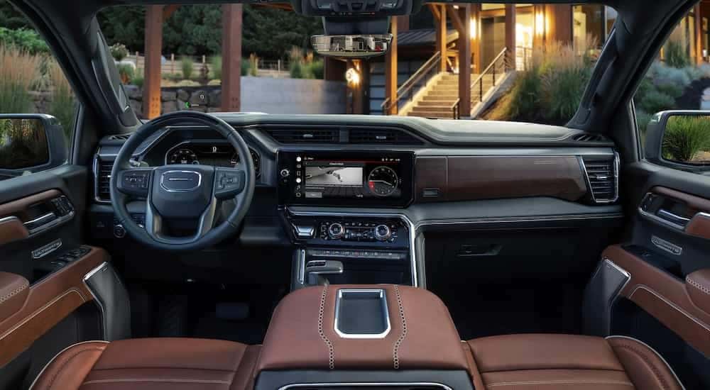The brown interior of a 2024 GMC Sierra 1500 Denali Ultimate is shown from above the center console.