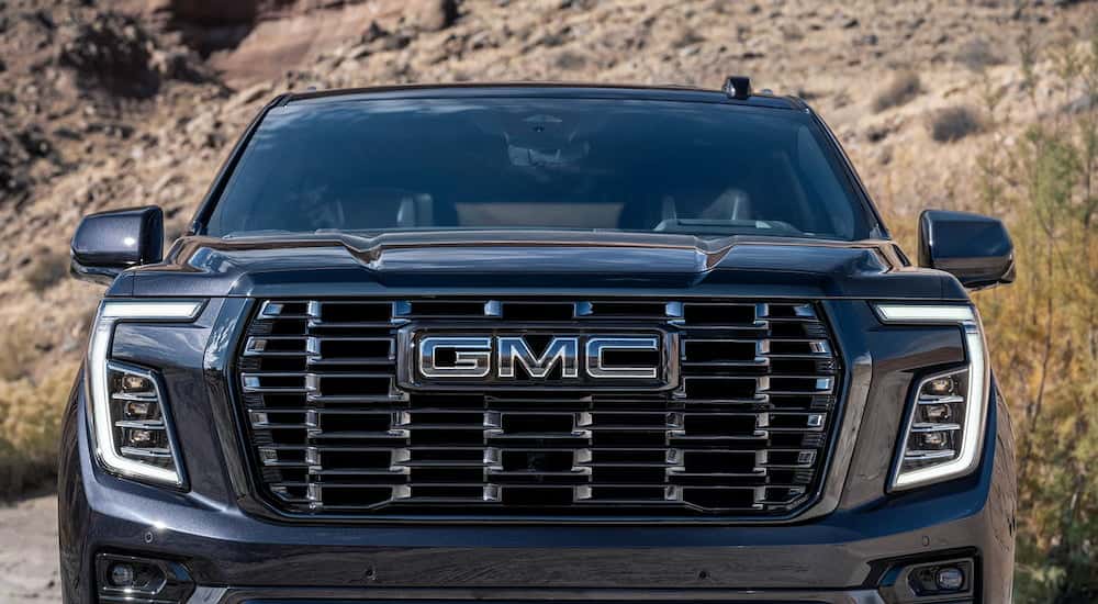 Close-up on the grille and badge of a blue 2025 GMC Yukon XL for sale.