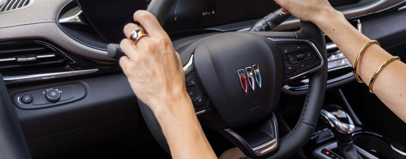 A close-up shows a steering wheel in a 2024 Buick Envista Avenir.