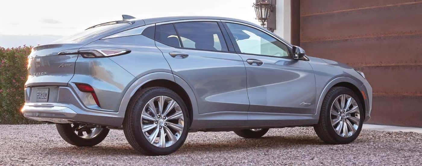 A silver 2024 Buick Envista Avenir is parked in front of a garage.