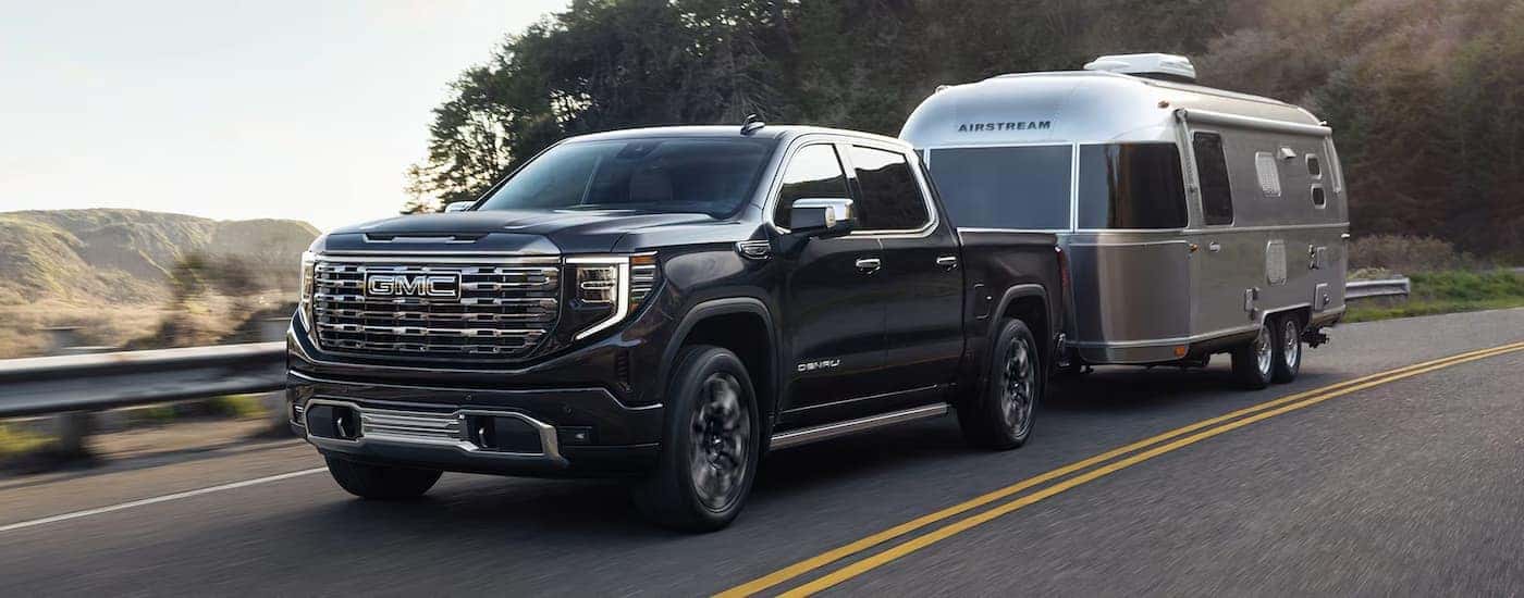 A black 2025 GMC Sierra 1500 Denali towing an Airstream trailer