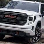 A white 2025 GMC Sierra 1500 AT4 off-roading.
