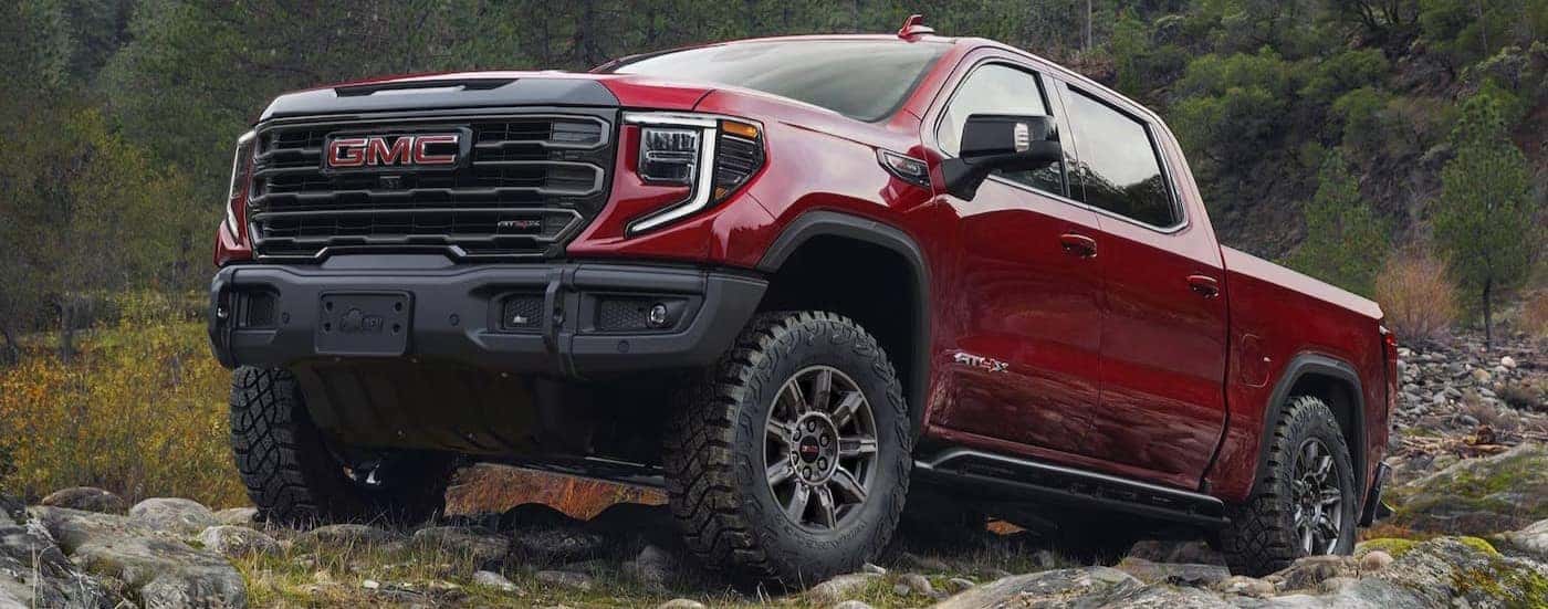 A red 2025 GMC Sierra 1500 AT4X parked off-road.
