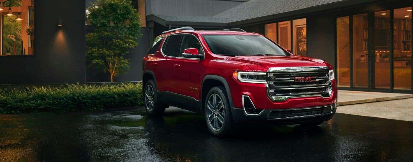 A red 2023 GMC Acadia is shown from the front at an angle.