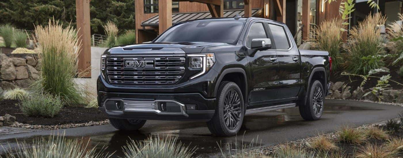 A black 2022 GMC Sierra 1500 Denali Ultimate is shown from the front at an angle after leaving a dealer that has a GMC Sierra 1500 for sale.