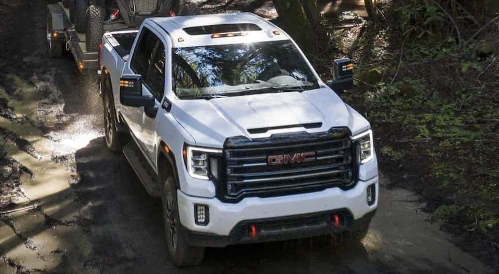 A white 2023 GMC Sierra 2500 HD AT4 driving off-road