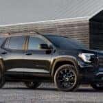 A black 2025 GMC Terrain Elevation parked near a house.