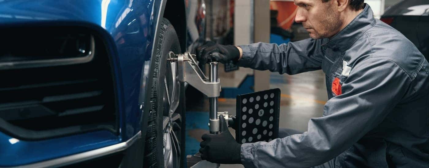 Technician doing a wheel alignment at a Buick service center