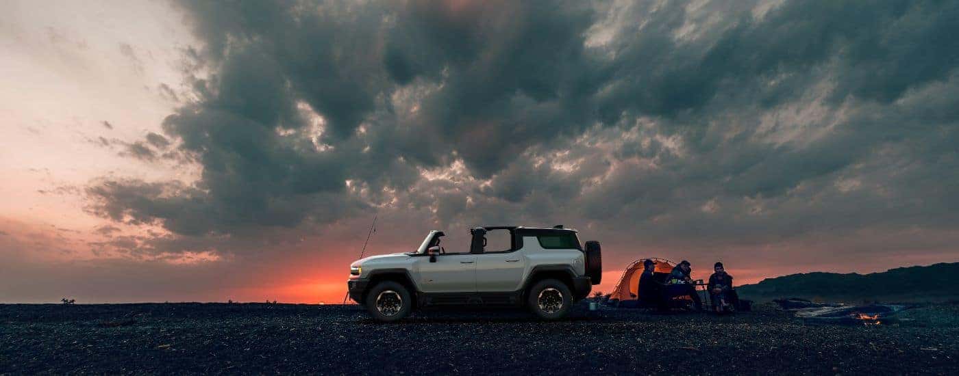 White 2024 GMC Hummer EV off-road at dusk