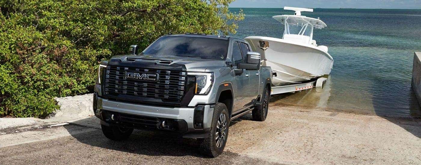 Grey 2026 GMC Sierra 2500 HD Denali Ultimate towing a boat