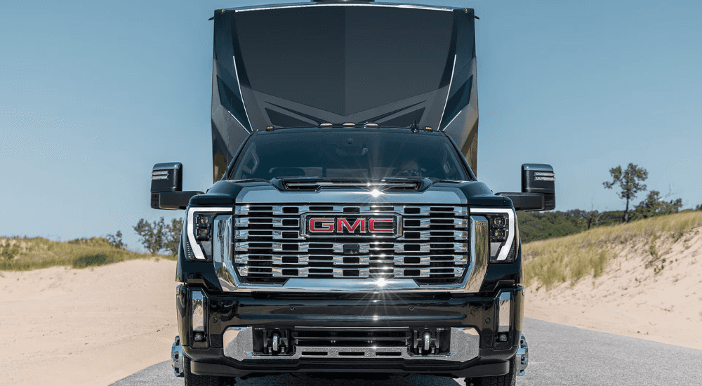 Black 2026 GMC Sierra 2500 HD towing a camper