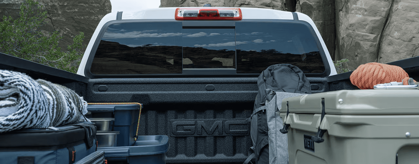 The bed of a silver 2026 GMC Canyon filled with gear