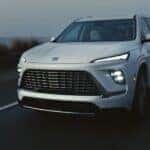 A white 2026 Buick Enclave driving on a highway.