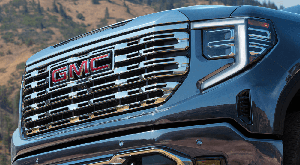 Grille and front badging of a blue 2026 GMC Sierra 1500